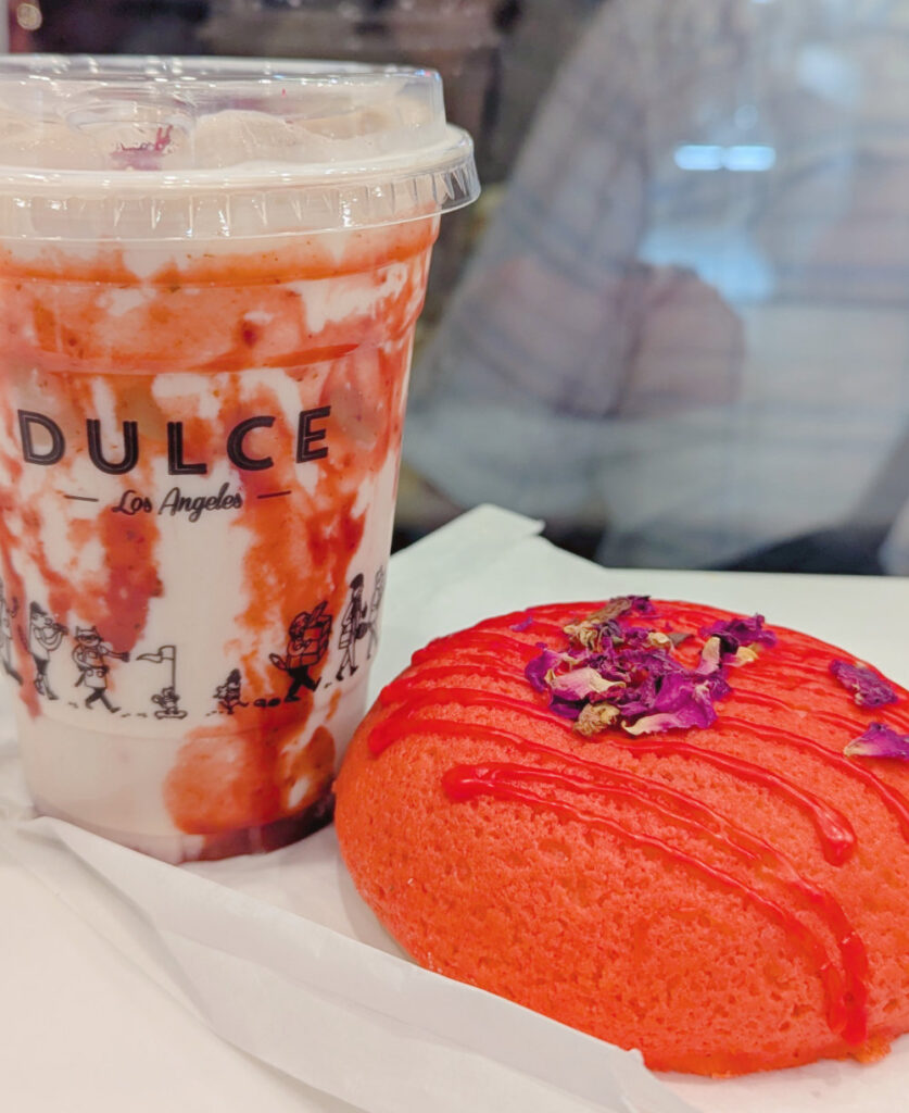Close up photo of iced tea drink and red bun