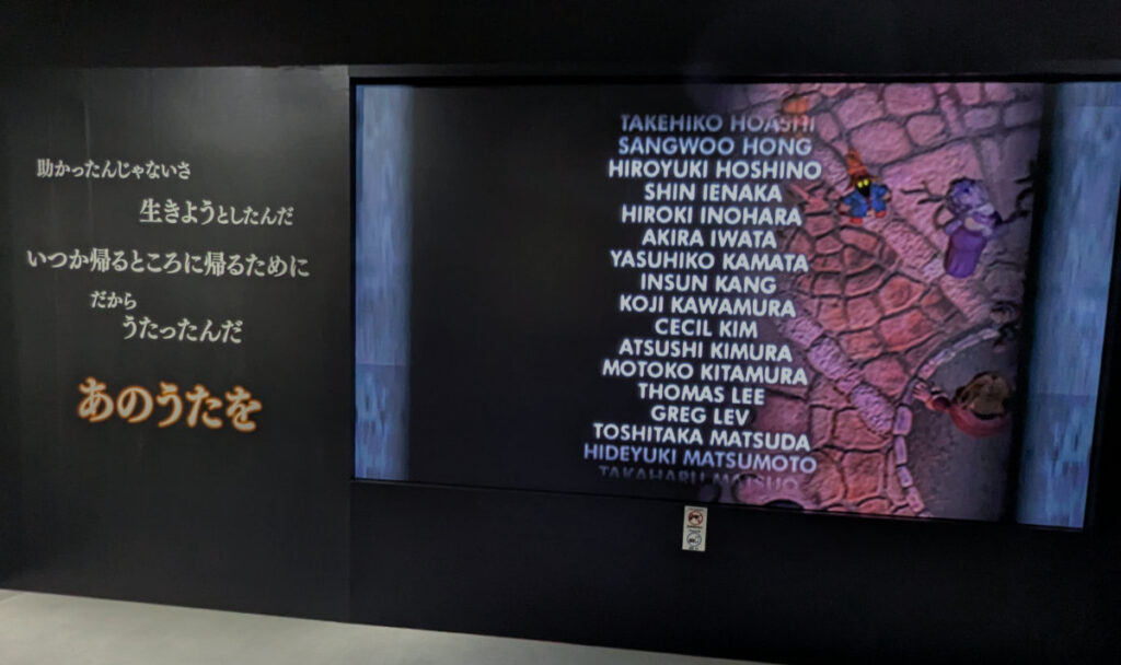 FFIX credits running on a wall with song lyrics from the theme song on the wall in Japanese