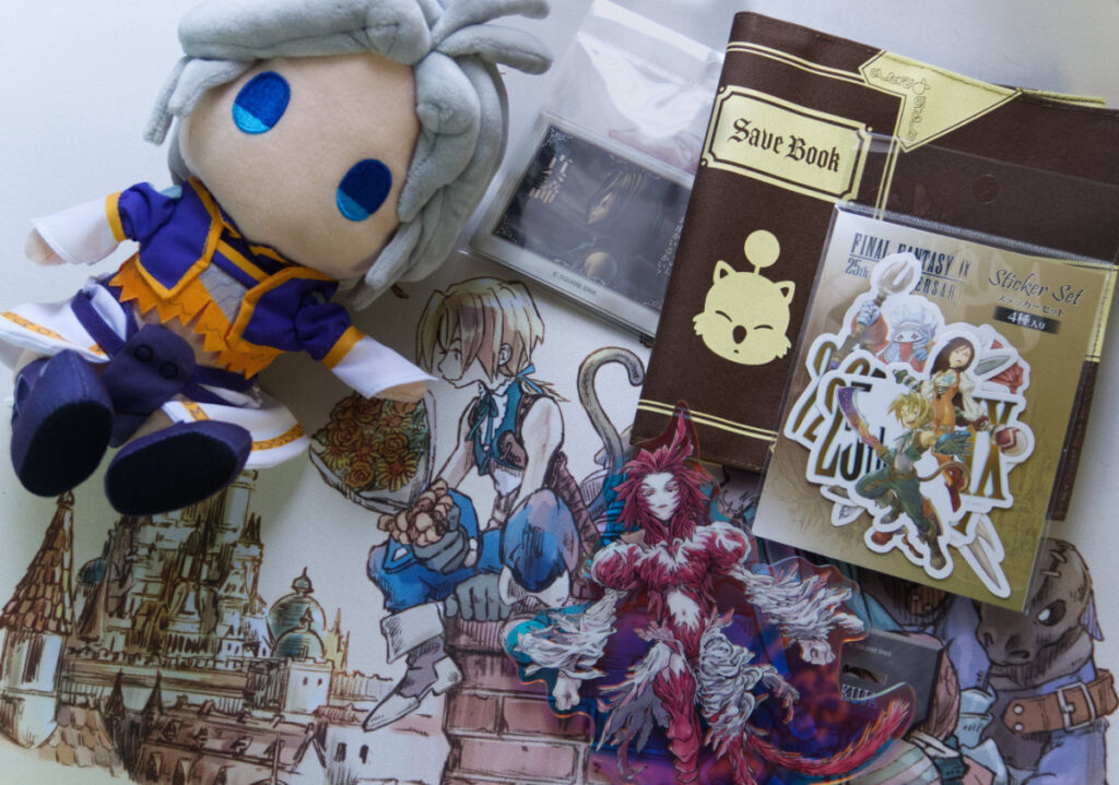 Flatlay of a chibi Kuja plushie, FFIX desk mat, Moogle Save Book book cover, various FFIX stickers, and a trance Kuja acrylic stand